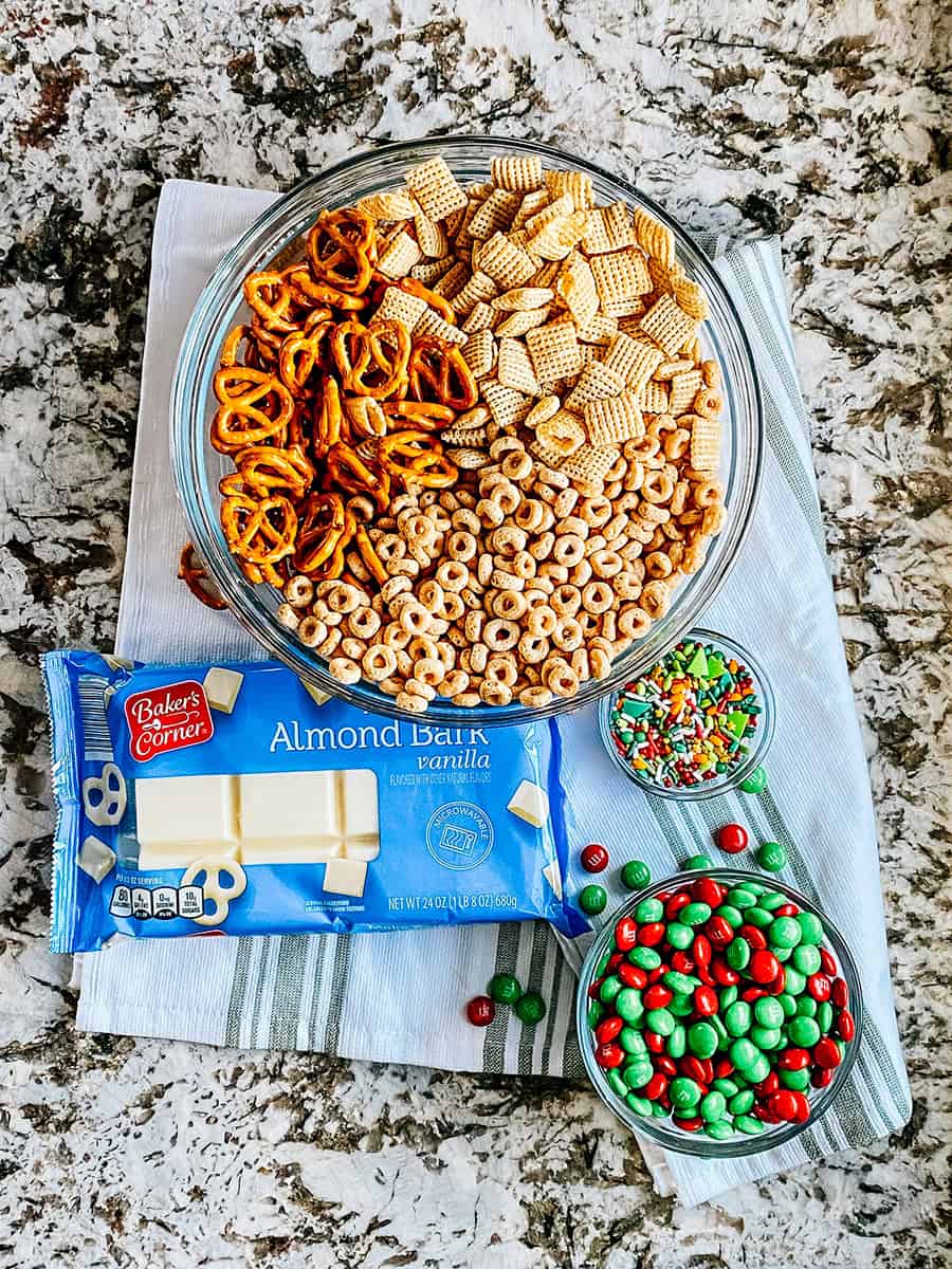 Ingrédients pour le mélange de fruits secs au chocolat blanc : bretzels, carrés de riz, Cheerios, M&Ms, chocolat blanc et vermicelles.