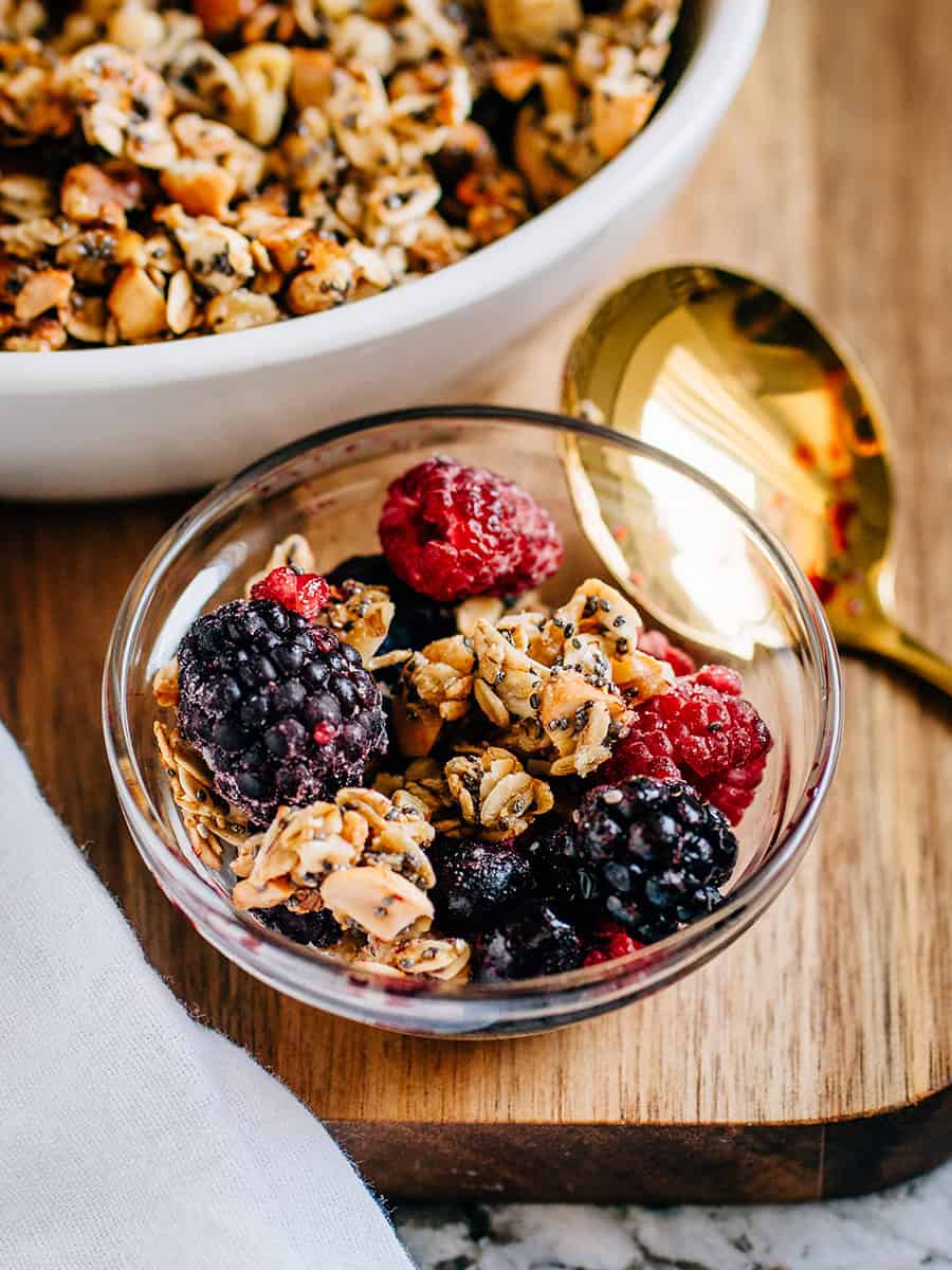 Un petit bol de granola fait maison mélangé avec des fruits congelés, prêt à être servi.