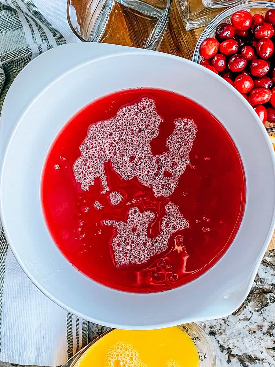 Canneberges et ananas dans un grand bol de mélange pour le punch de Noël.