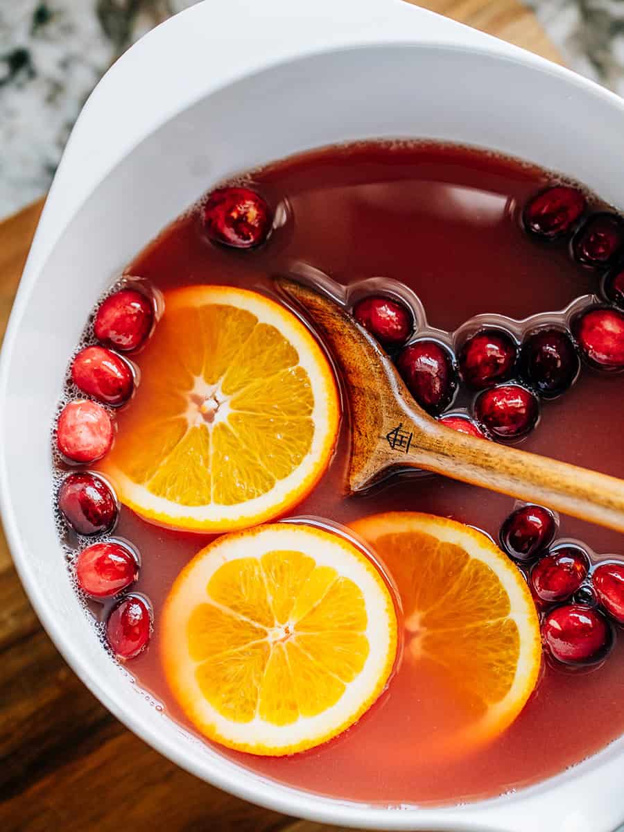 Un bol de punch de Noël avec des canneberges et des tranches d'orange. Un punch convivial pour la famille.