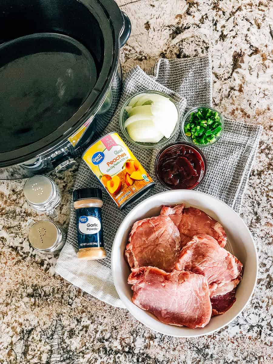 Ingrédients pour les côtelettes de porc à la pêche en cocotte : côtelettes de porc épaisses, pêches, sauce barbecue, oignons, jalapeños hachés, poudre d'ail, sel et poivre.