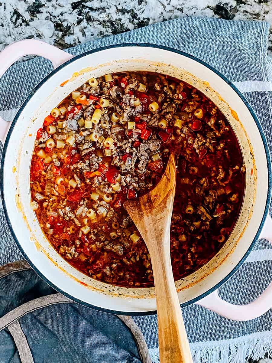 Nouilles, tomates en dés et épices mélangées et prêtes à mijoter.