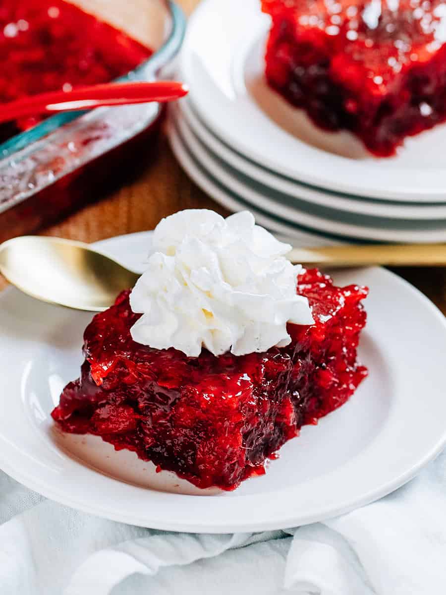 Gélatine de canneberge avec ananas écrasé, sauce aux canneberges et gélatine de framboise complètement prise et garnie d'une cuillerée de topping crémeux fouetté !