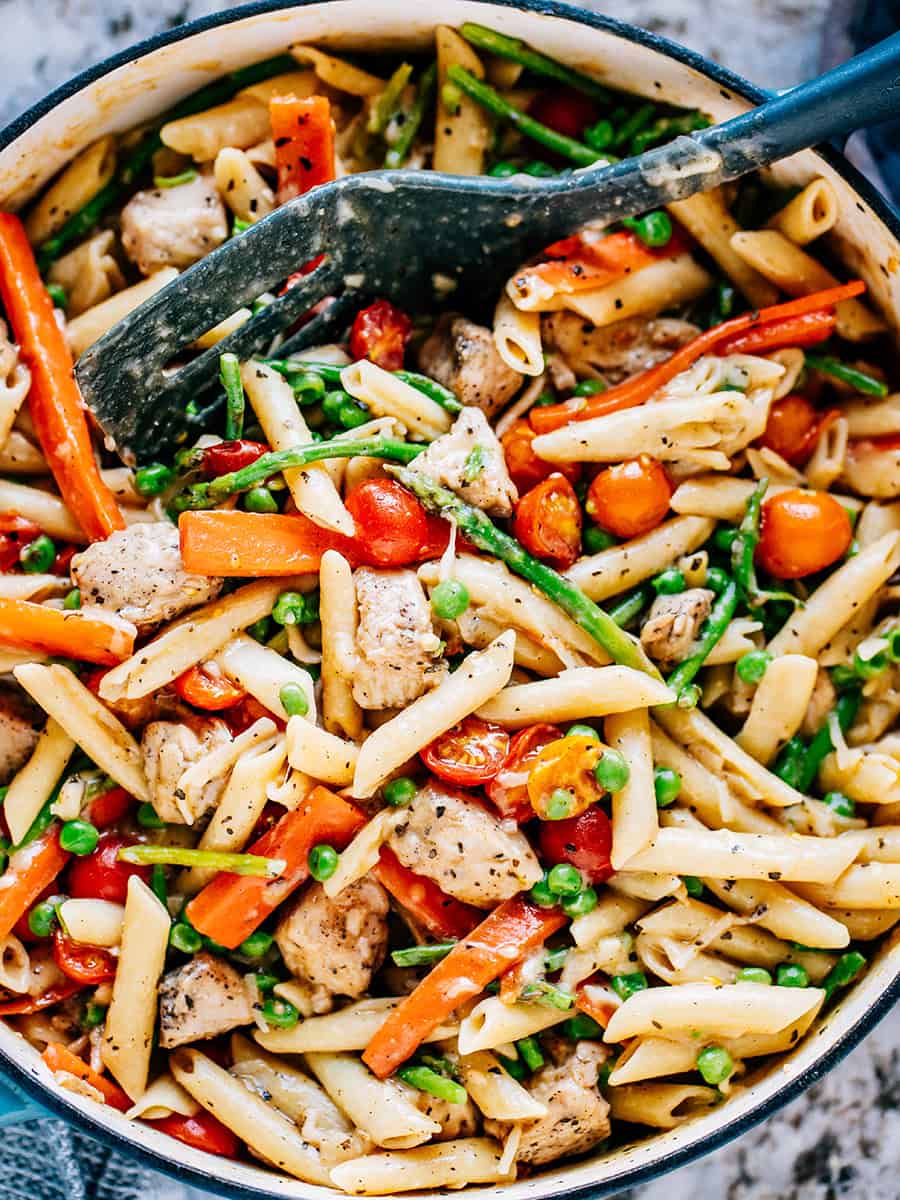 Vue d'ensemble du poulet primavera dans une cocotte montrant toutes les couleurs de cette merveilleuse idée de plat en une seule casserole.