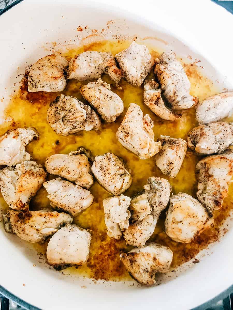 Morceaux de poulet frits complètement cuits dans une grande cocotte.