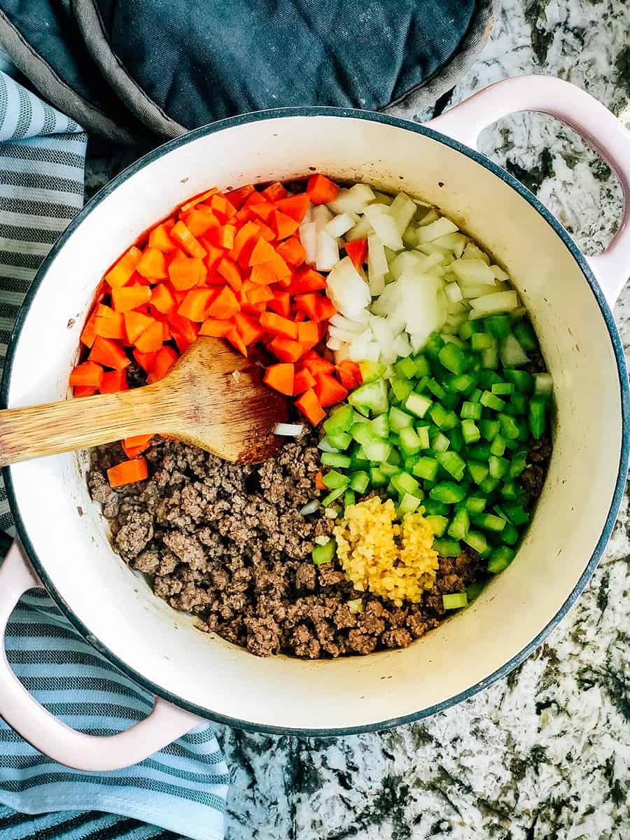 Étape deux pour la soupe Pasta E Fagioli : Ajoutez les légumes en dés et hachés et l'ail.