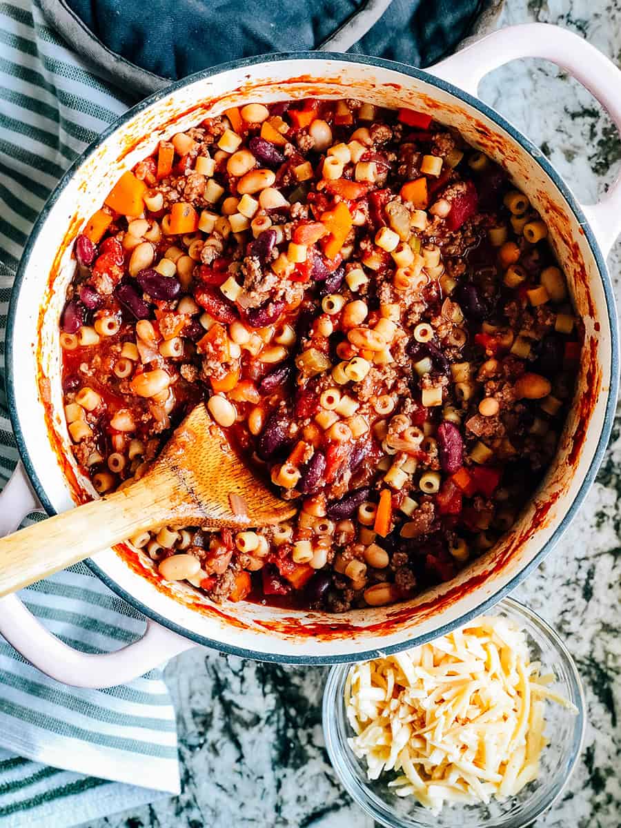 Pâtes cuites ajoutées et mélangées dans la soupe Pasta E Fagioli mijotée.