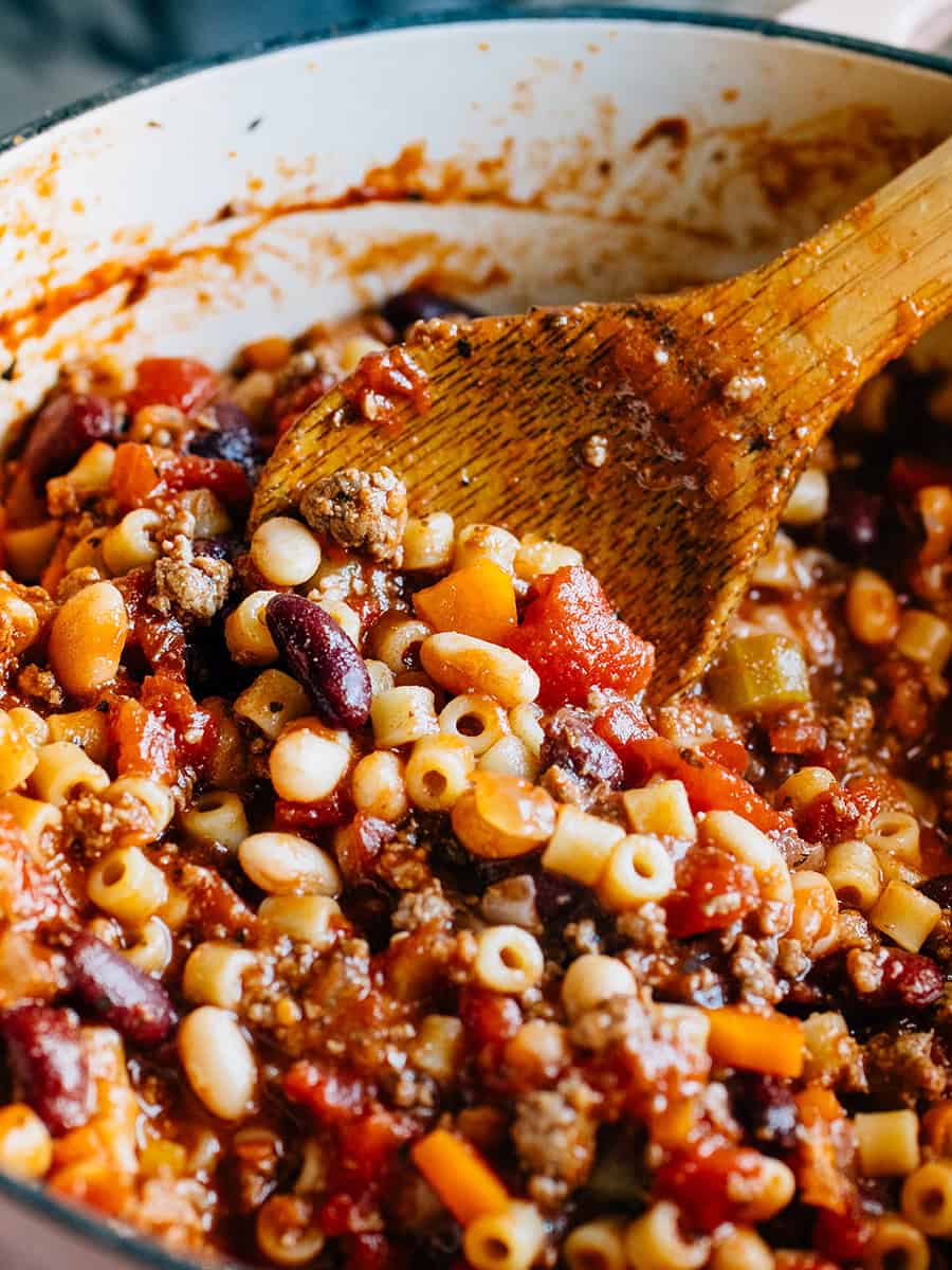 Soupe complète Pasta E Fagioli dans une casserole en gros plan. C'est une soupe copieuse faite avec de la viande hachée, de délicieux haricots, des légumes tendres et des pâtes Ditalini avec du parmesan fraîchement râpé à côté.