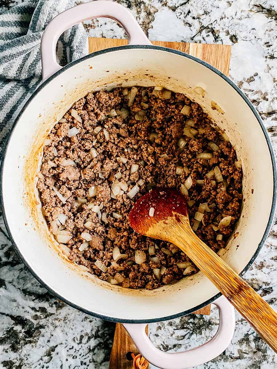 Boeuf haché doré avec de l'ail émincé et des oignons dans une grande casserole.