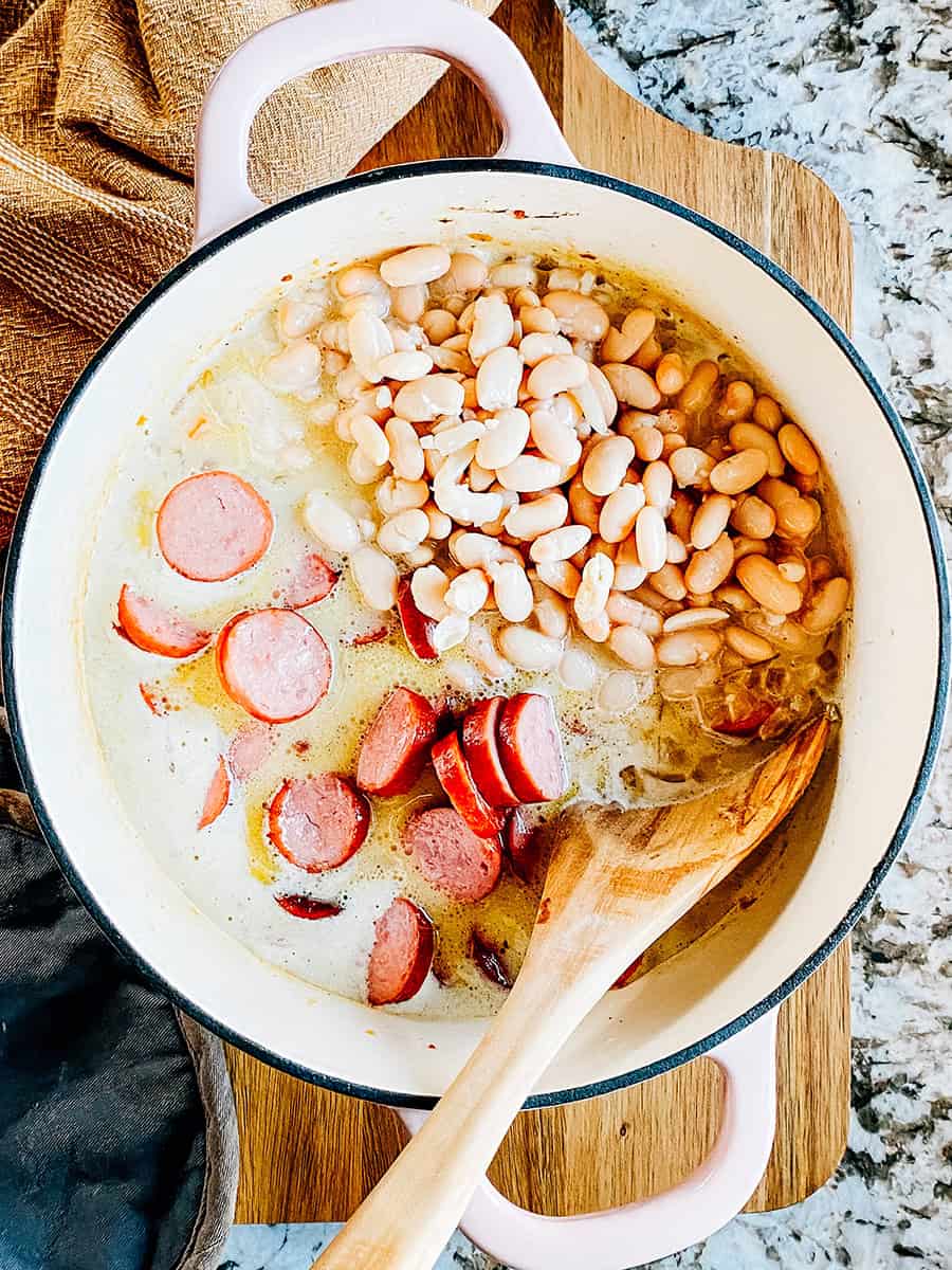 Kielbasa et haricots ajoutés à la casserole pour une délicieuse soupe crémeuse de kielbasa.