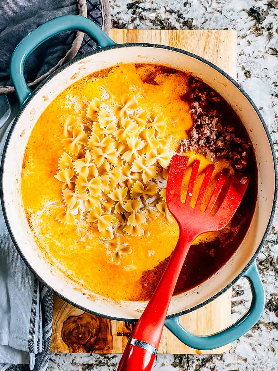 Bouillon de boeuf, crème épaisse et pâtes en nœud papillon non cuites ajoutées au boeuf assaisonné.