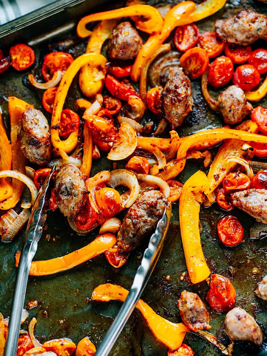 Browned Italian sausage and tender vegetables on a sheet pan in a homemade marinade.