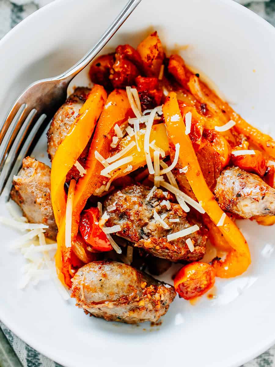 Top view of sheet pan sausage and peppers in a bowl.