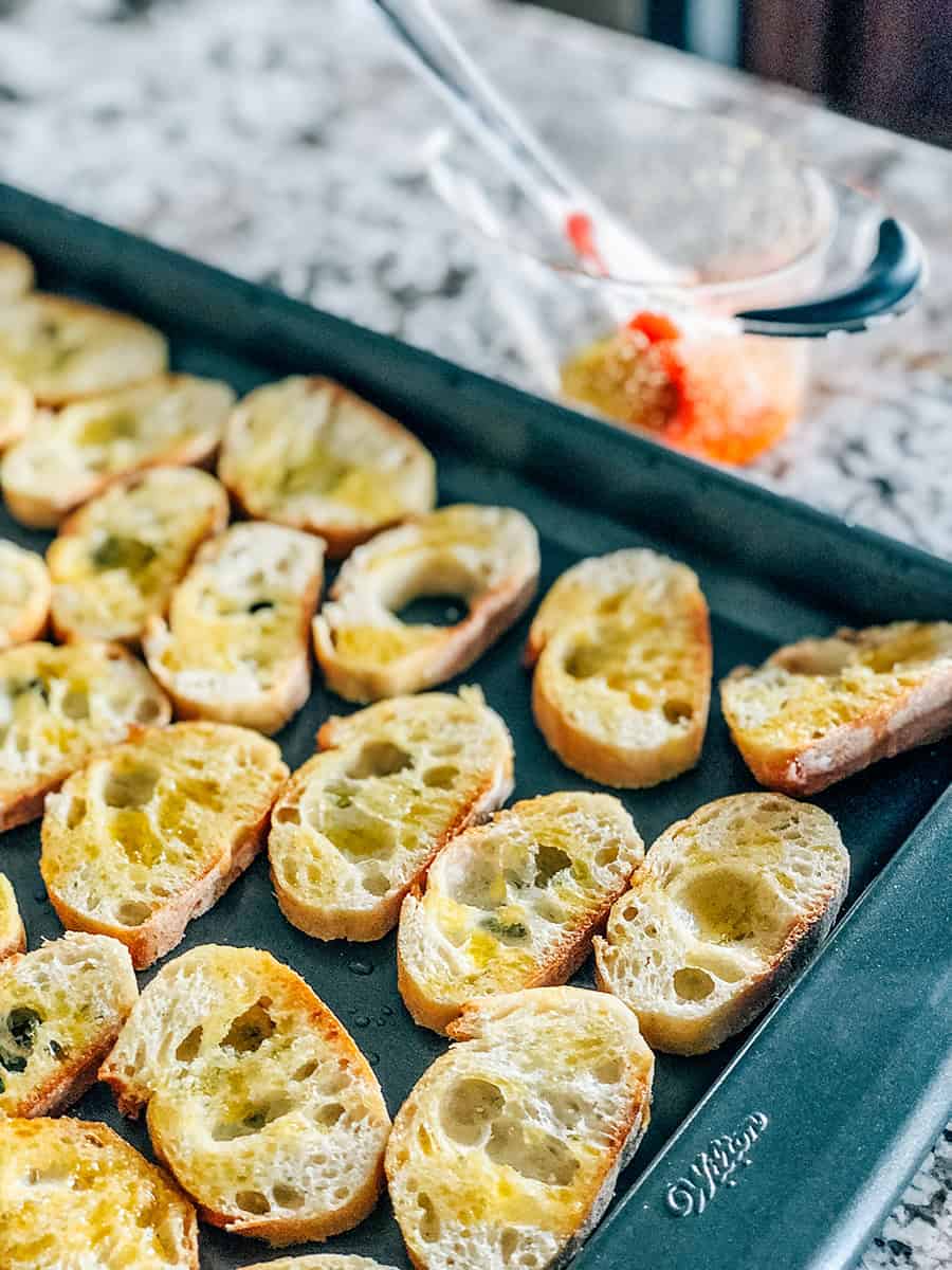 Tranches de baguette badigeonnées d'un mélange d'huile d'olive et de poudre d'ail.