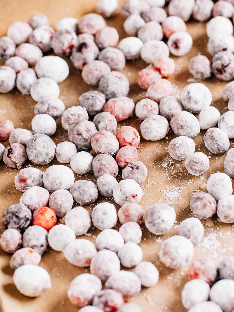 Delicious candid cranberries on a baking sheet lined with parchment paper.