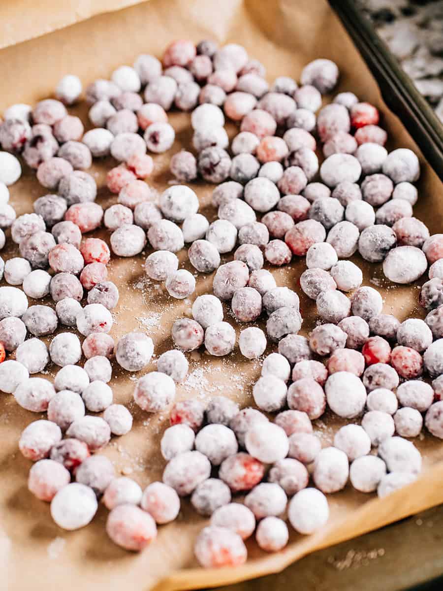 Sweet candid cranberries on a baking sheet.