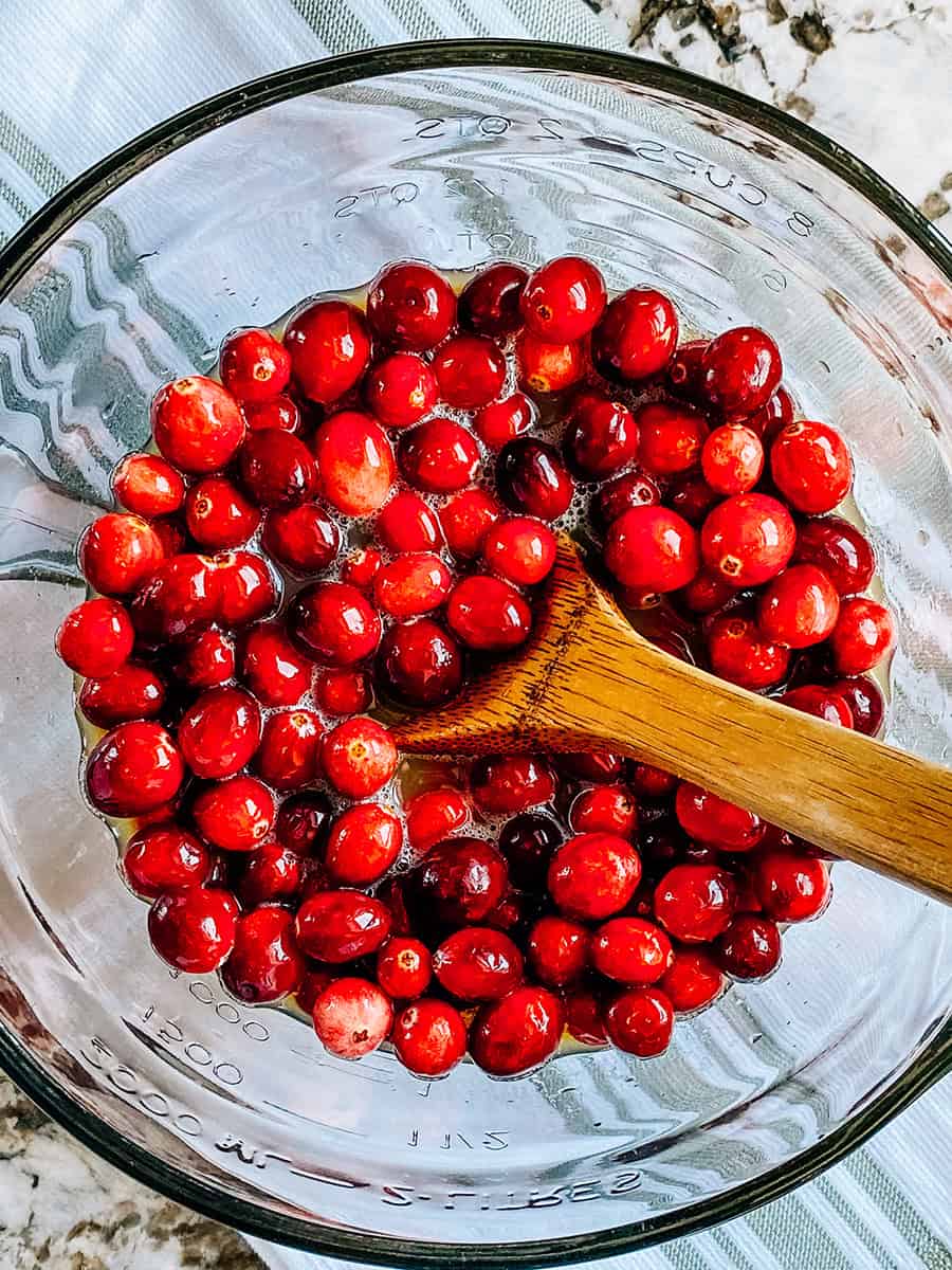 Cranberries in a bowl with 7-up and orange juice.