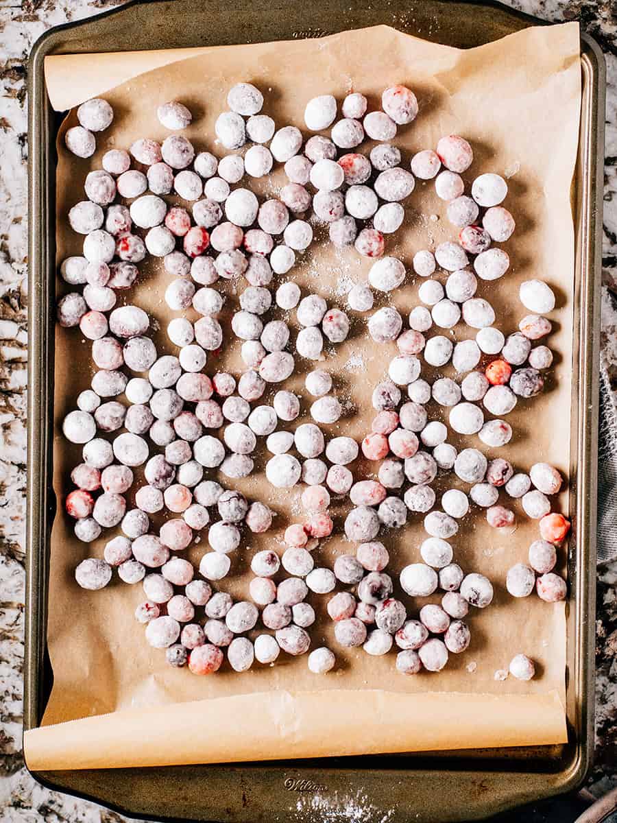 Candid cranberries cooling a baking sheet.