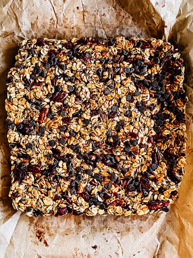 Le bloc de barres granola sur un morceau de papier sulfurisé.