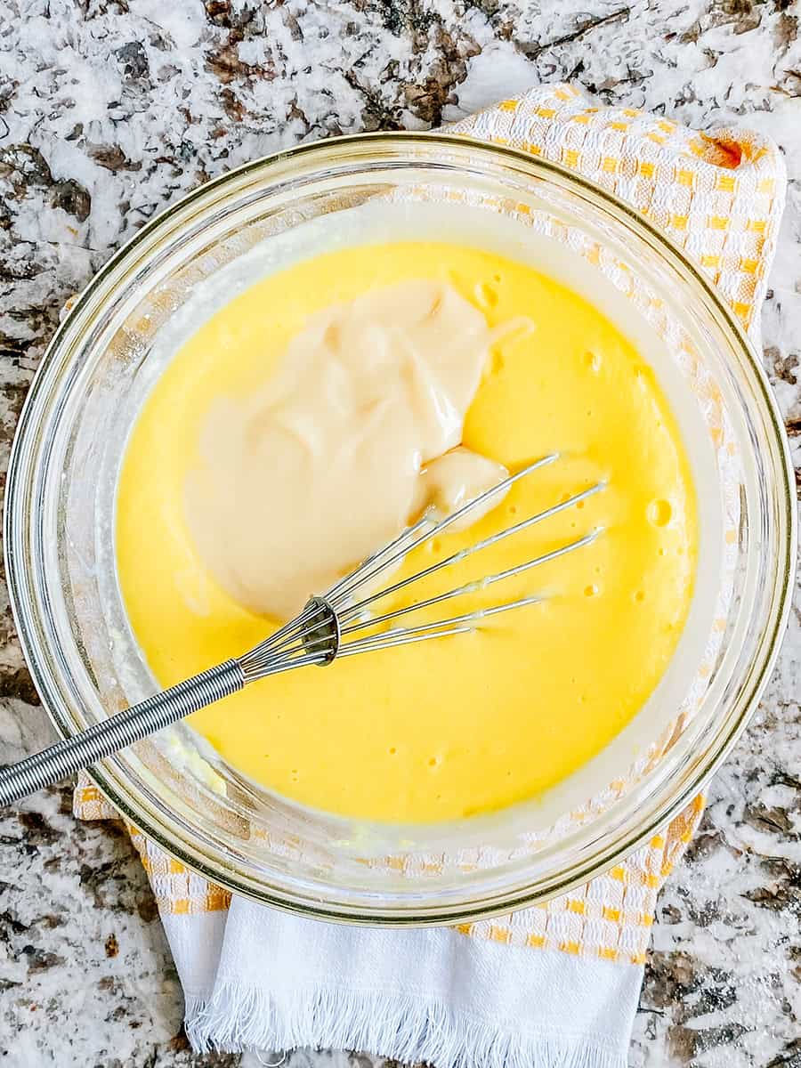Lait concentré sucré versé dans le pudding qui commence à épaissir.