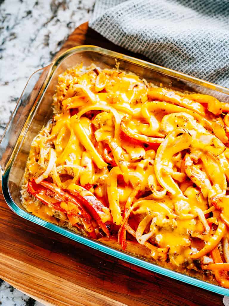 Fromage cheddar fondu sur du poulet cuit, des poivrons et des oignons assaisonnés avec des épices fajita.