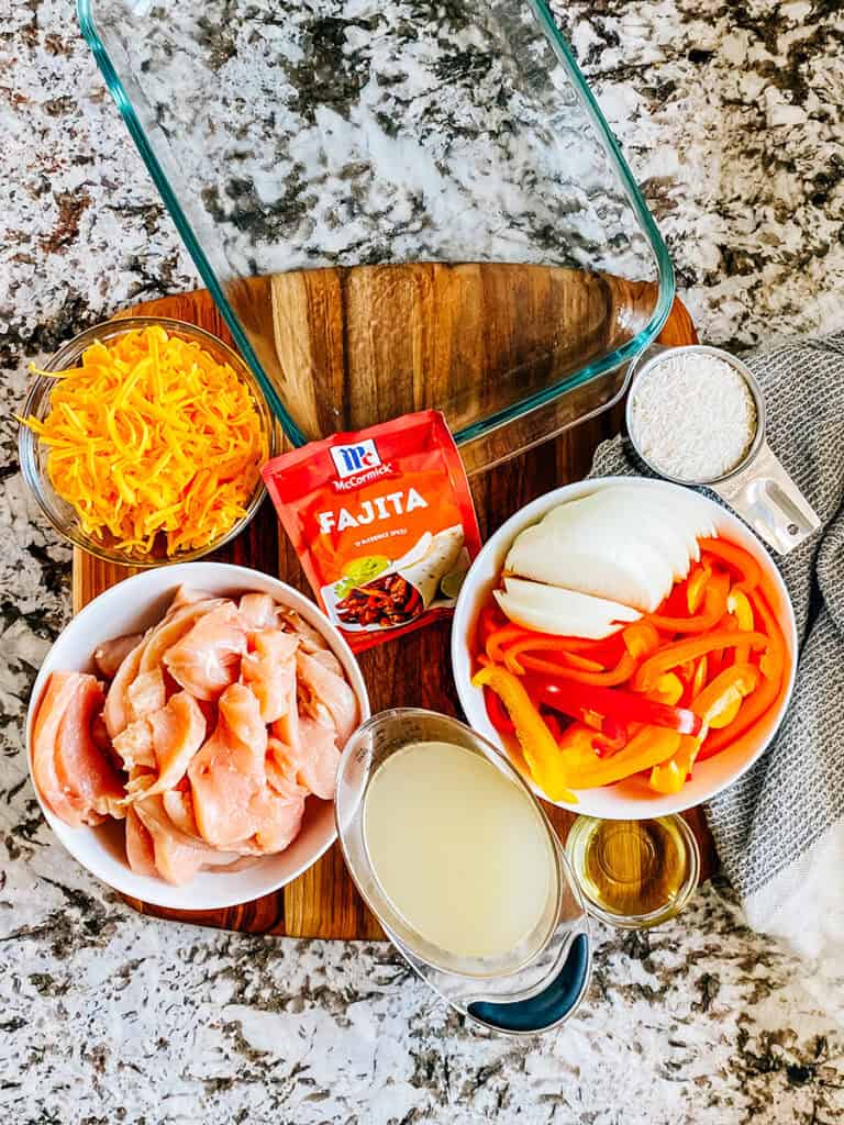 Les ingrédients pour cette casserole de poulet fajita : poitrines de poulet tranchées, poivrons et oignons tranchés, huile, bouillon de poulet, riz, fromage cheddar râpé et assaisonnement fajita.