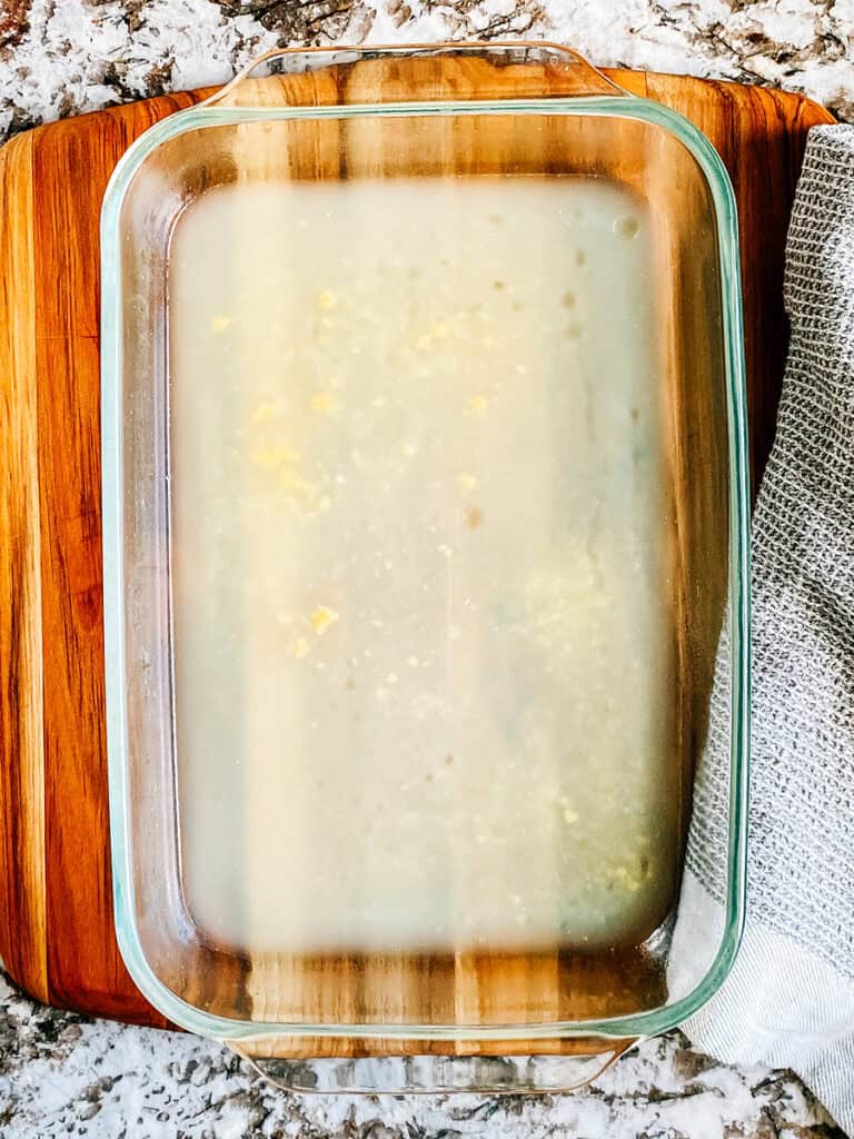 Un plat de cuisson de 23x33 cm avec du bouillon de poulet au fond.