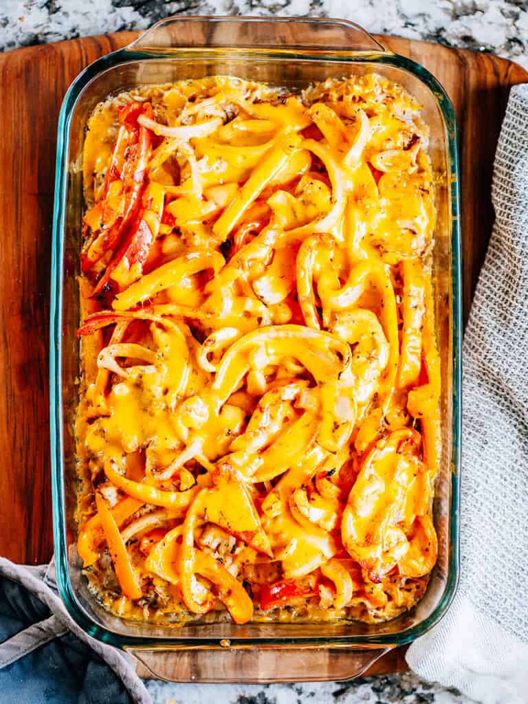 Fromage fondu sur le poulet assaisonné fajita et les légumes.