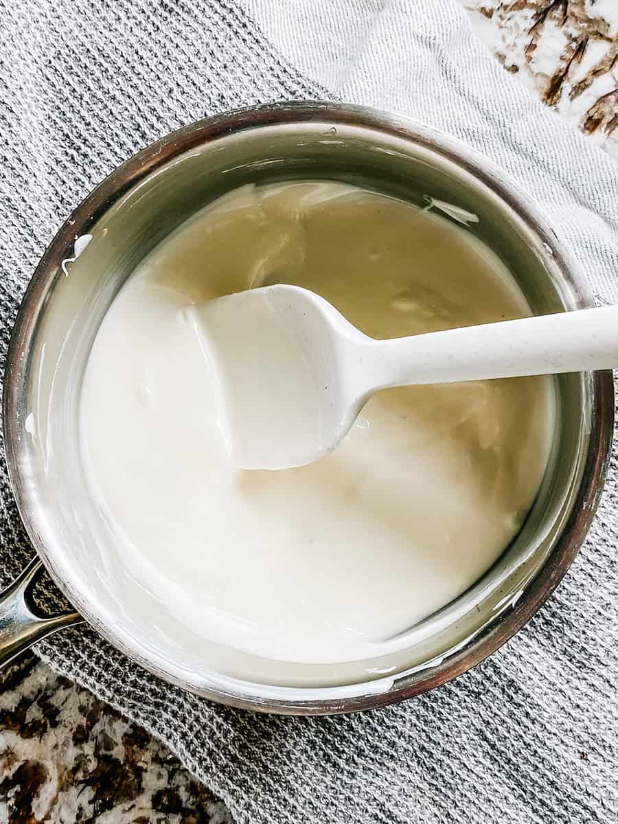 Chocolat d'amande fondu, un enrobage sucré à la vanille, dans une casserole.