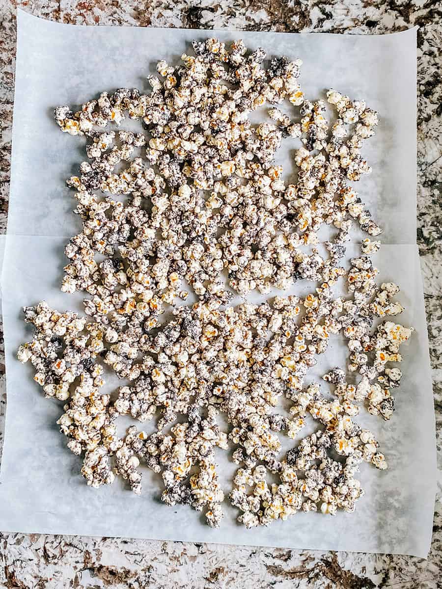 Pop-corn complètement enrobé étalé en une seule couche sur du papier sulfurisé.